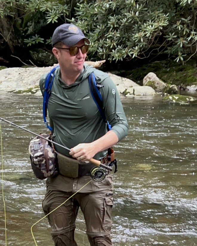 Shaun McCarren, founder of RouteHouse, fly fishing in a river